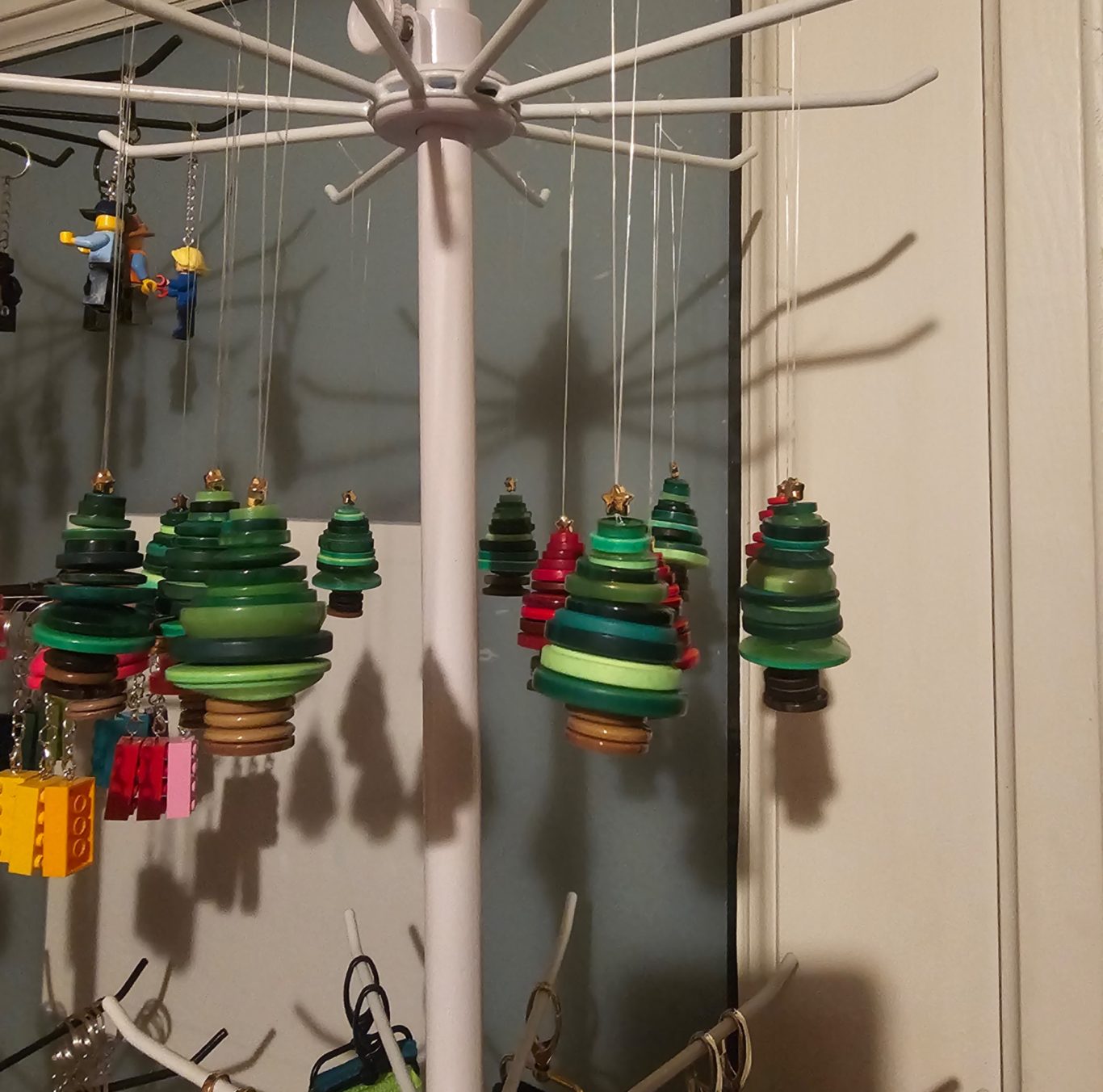 Weihnachtsbaum-Baumanhänger aus Knöpfen Bunte, hängende Weihnachtsbaum-Anhänger in verschiedenen Grüntönen und roten Akzenten.