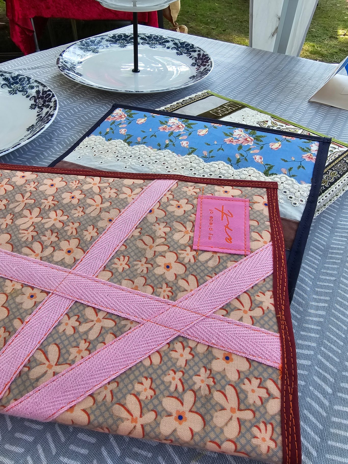 Kladdenhülle Bunt gestaltete Kladdenhüllen aus Stoff, mit floralen und geometrischen Mustern.