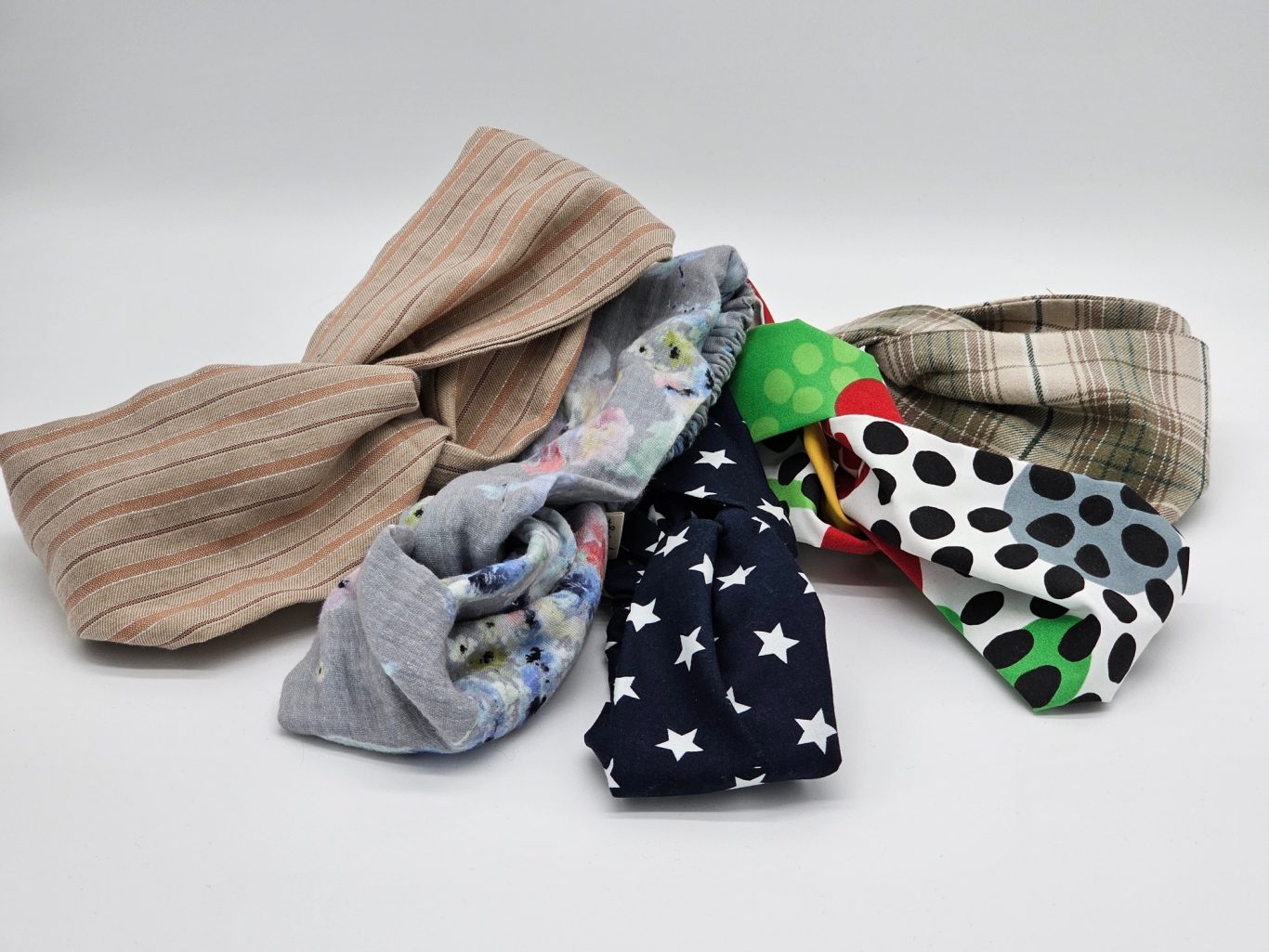 Upgecyceltes Haarband Bunte Haarbänder liegen übereinander auf einer flachen Oberfläche.