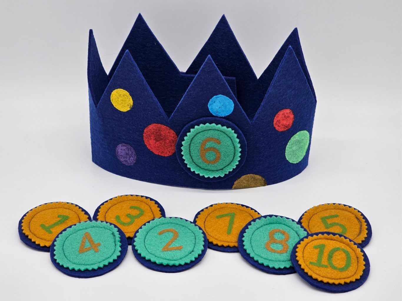 Geburtstagskrone Ein blauer Kinderkrone mit bunten Punkten und Zahlenplättchen von 1 bis 10.