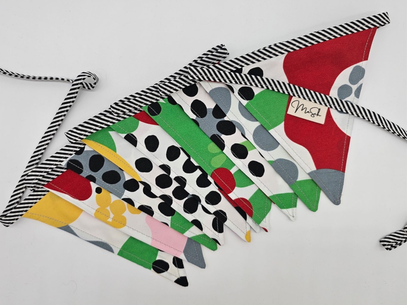 Upgecycelte Wimpelkette Bunt gemusterte Wimpel aus Stoff in verschiedenen Farben und Formen.