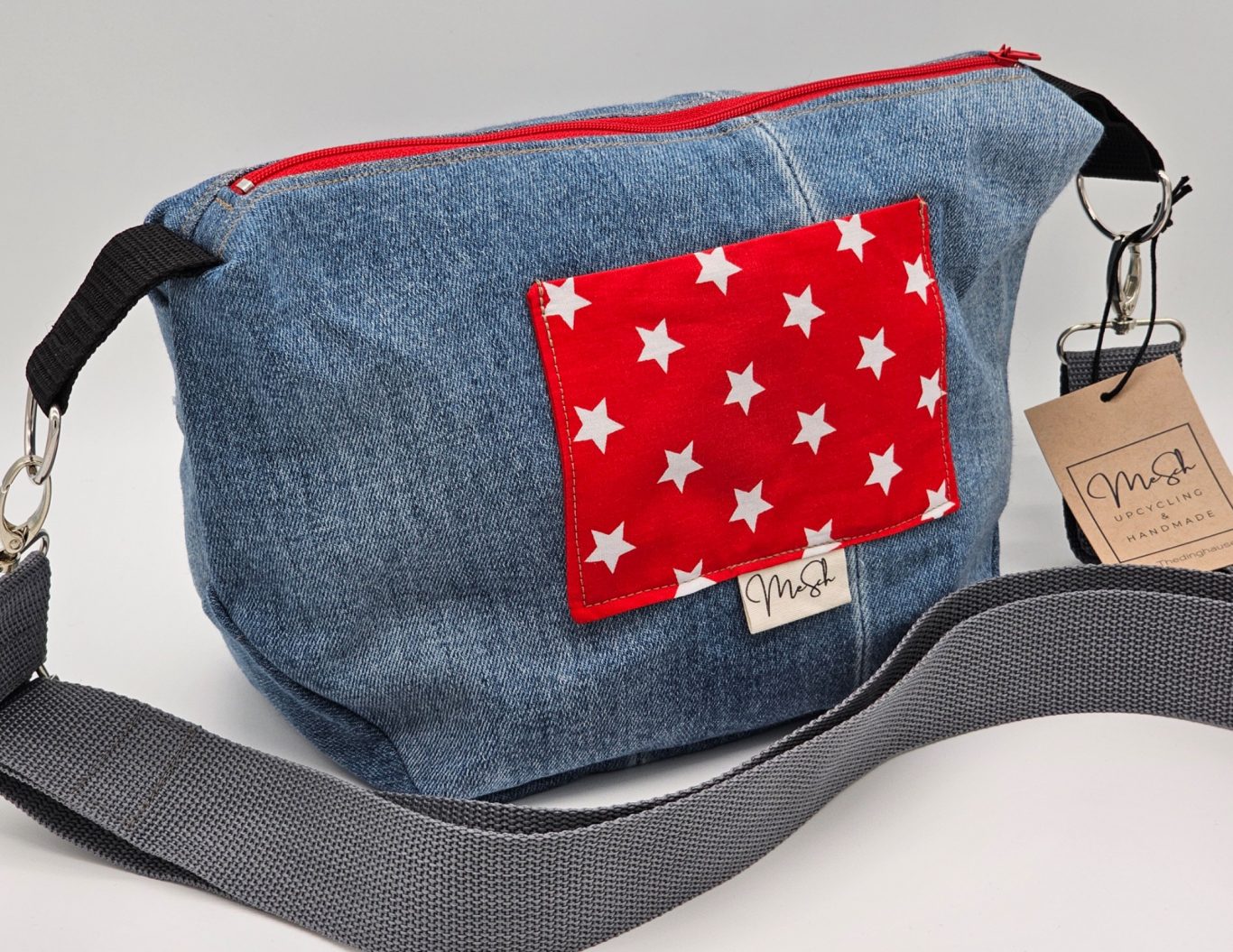 Upgecycelte Jeanstasche Umhängetasche aus Jeansstoff mit Sternen auf der Vorderseite und grauem Gurt.