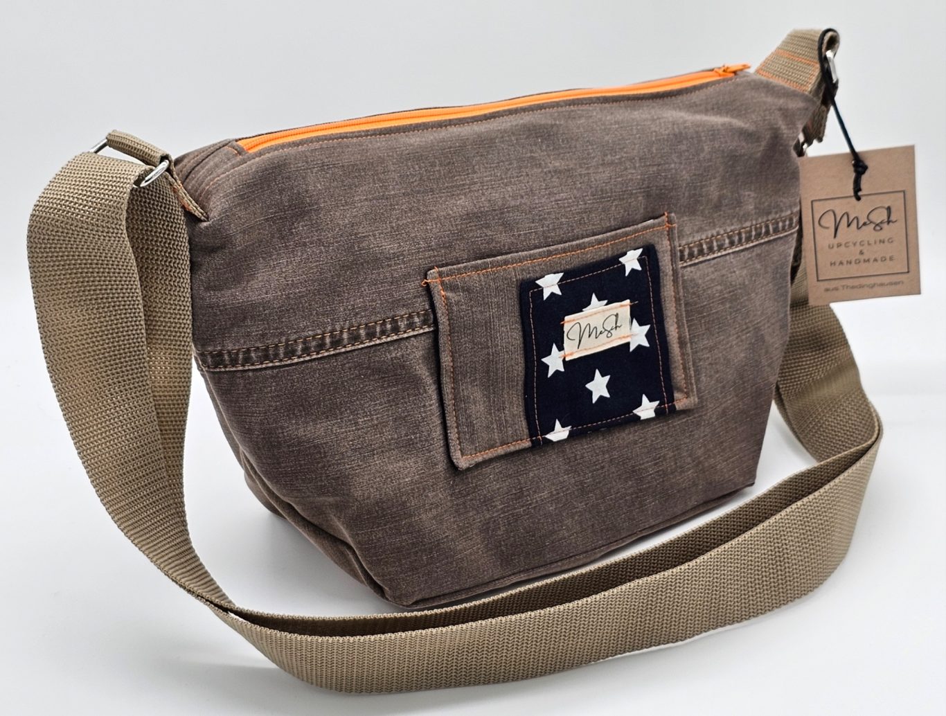 Upgecycelte Jeanstasche Braune Umhängetasche mit orangefarbenem Reißverschluss und Sternenmotiv auf der Vorderseite.