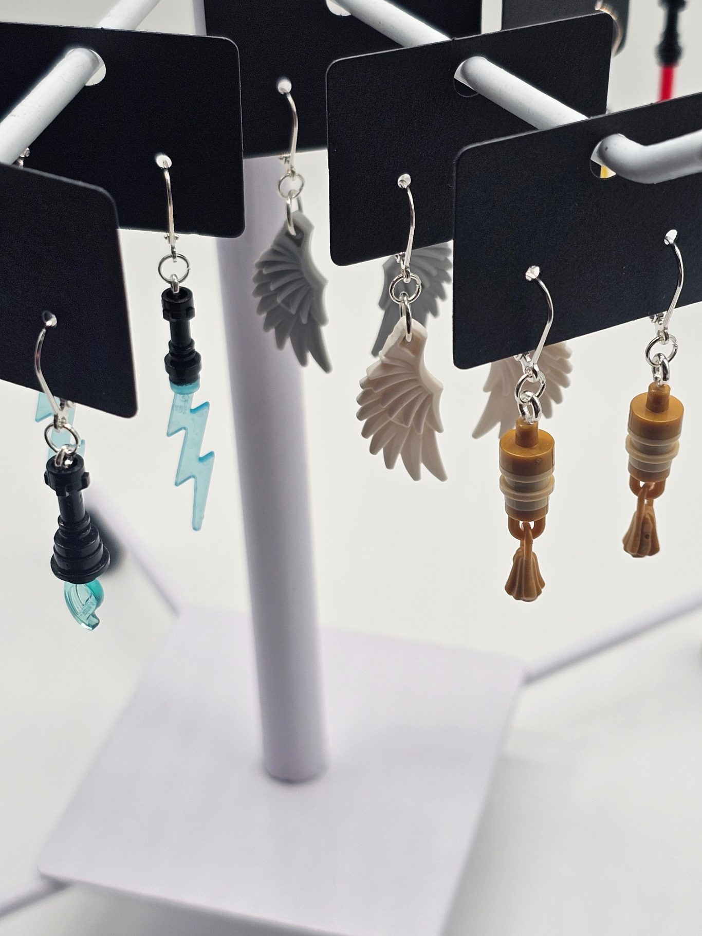 Upgecycelte Ohrringe (925er Silber) Bunte Lego-Ohrringe in verschiedenen Designs, darunter Blitz, Flügel und Holzbecher.