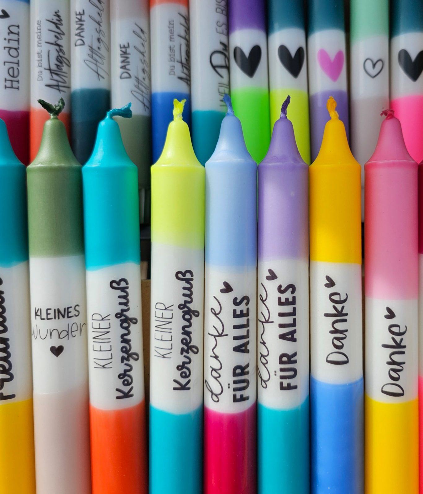Bunte Kerzen Bunte Kerzen in Reihen mit Sprüchen in verschiedenen Farben.