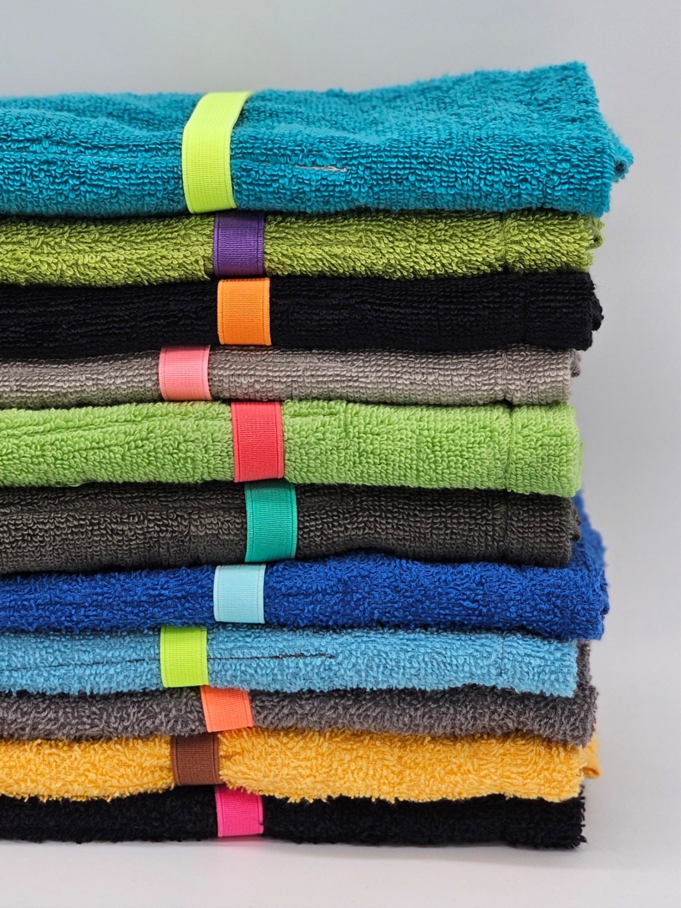 Upgecycelte Reiseutensilio Gestapelte Reiseutensilios in verschiedenen Farben mit bunten Bändern.