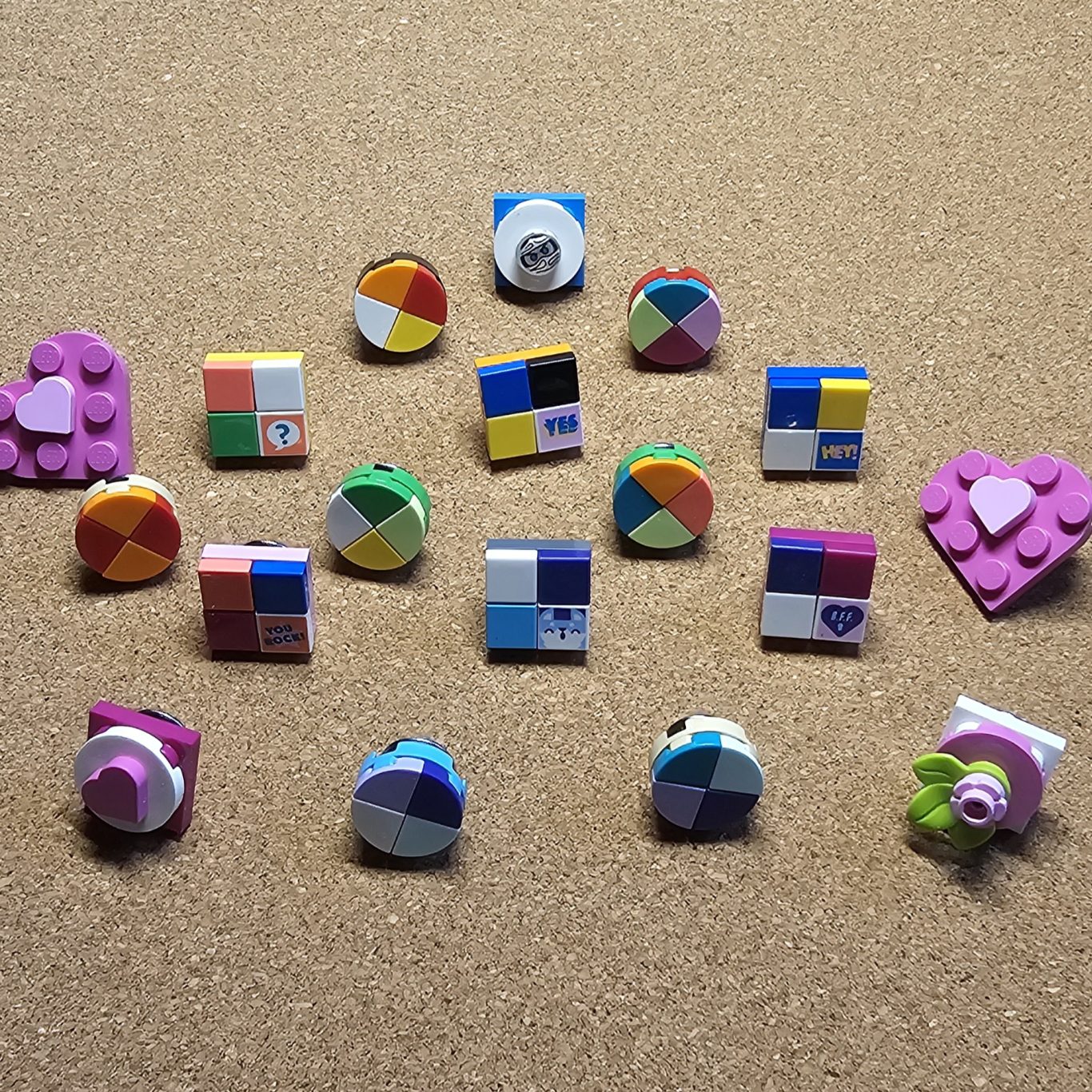 Upgecycelter kleiner Pin (Brosche) Bunte Pins also Broschen aus Legosteinen auf einer Korkplatte angeordnet.